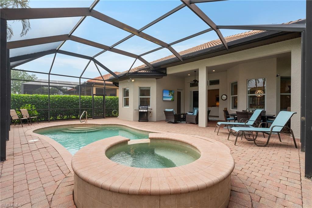 7806 Ashton Road Naples, FL 34113 - Photo 25 of 27 View of pool featuring a pool with connected hot tub, a patio, glass enclosure, ceiling fan, and a grill