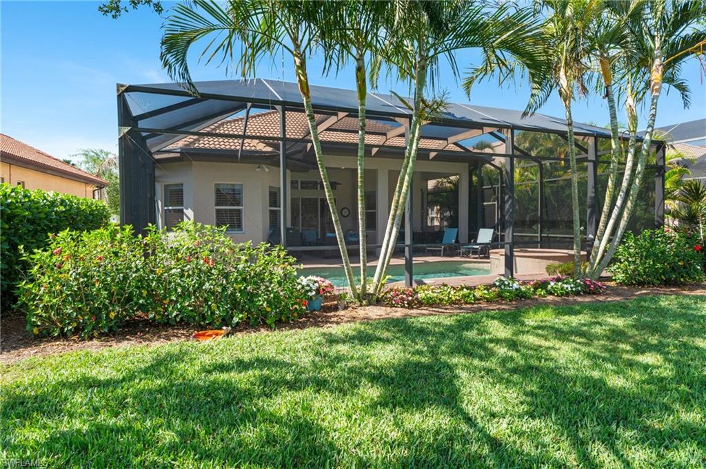 7806 Ashton Road Naples, FL 34113 - Photo 26 of 27 Rear view of property with glass enclosure, a lawn, stucco siding, and an outdoor pool