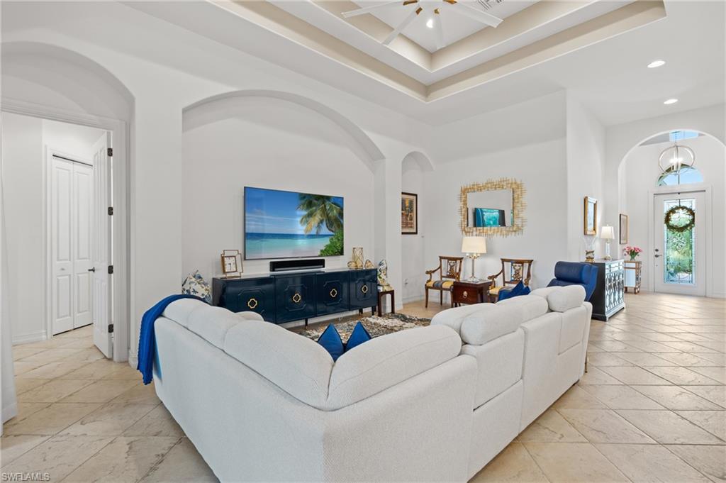 7806 Ashton Road Naples, FL 34113 - Photo 3 of 27 Living area featuring arched walkways, a towering ceiling, baseboards, and recessed lighting