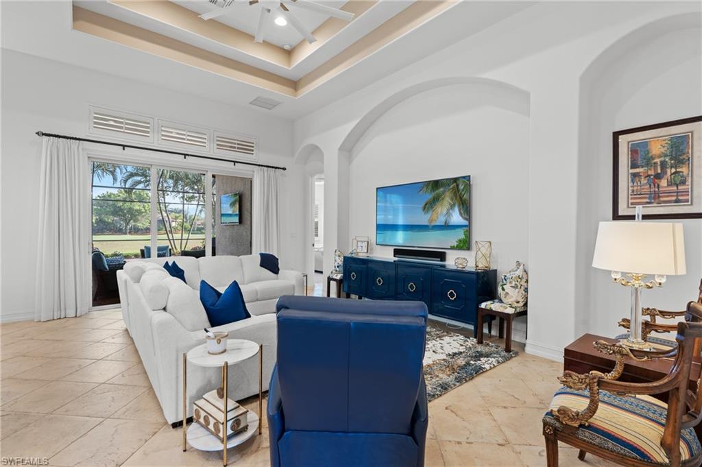 7806 Ashton Road Naples, FL 34113 - Photo 4 of 27 Living area with a raised ceiling, baseboards, visible vents, arched walkways, and ceiling fan