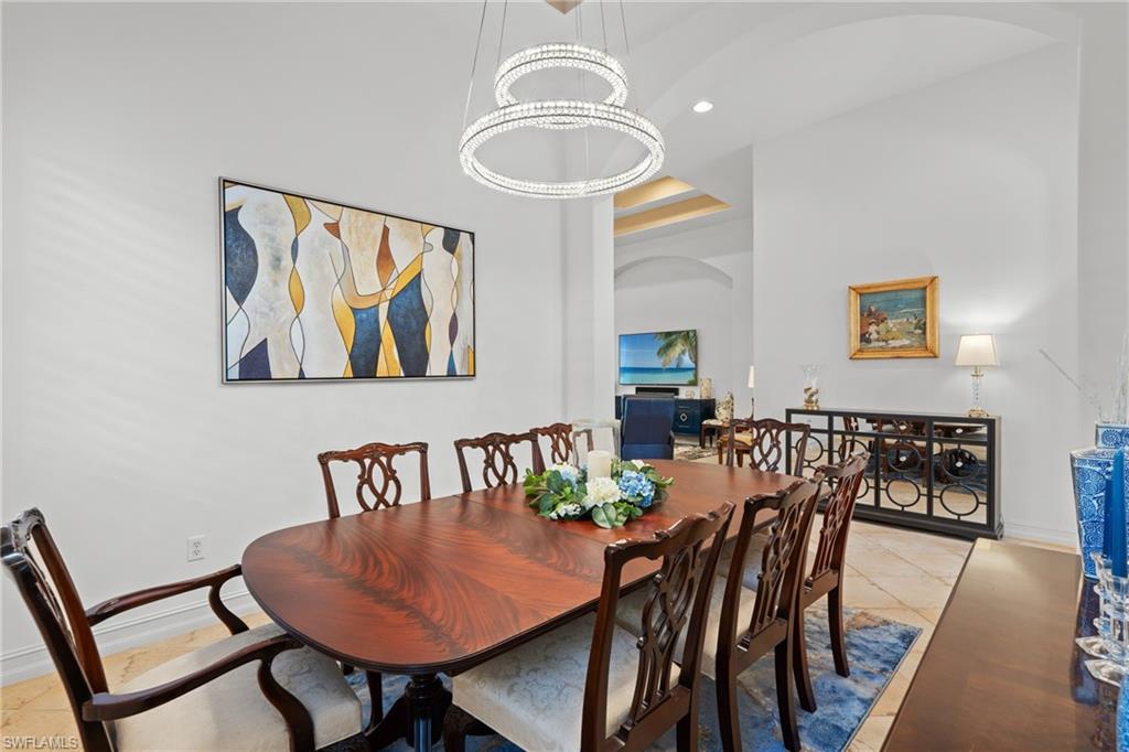 7806 Ashton Road Naples, FL 34113 - Photo 7 of 27 Dining room featuring recessed lighting, light tile patterned floors, baseboards, a towering ceiling, and arched walkways