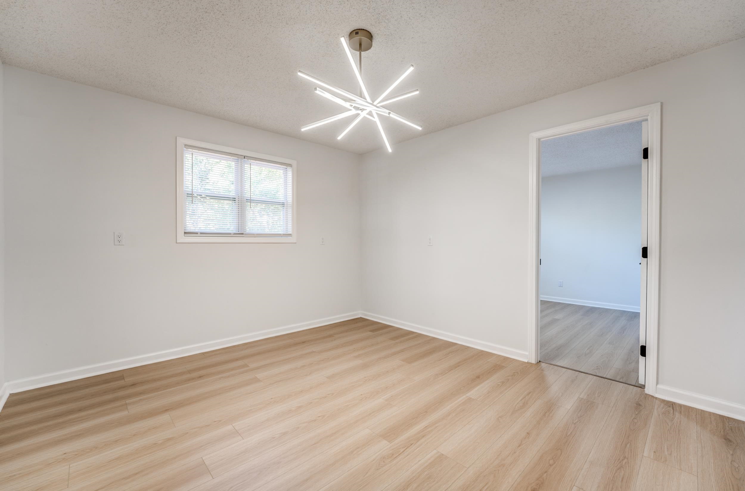 3060 Ruskin Road Bartlett, TN 38134 - Photo 21 of 30 Unfurnished room with a textured ceiling, light wood finished floors, and a chandelier