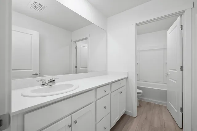 a bathroom with a sink double vanity granite tub and a mirror