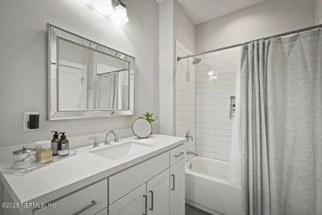 a bedroom with a bed a flat screen tv and couches