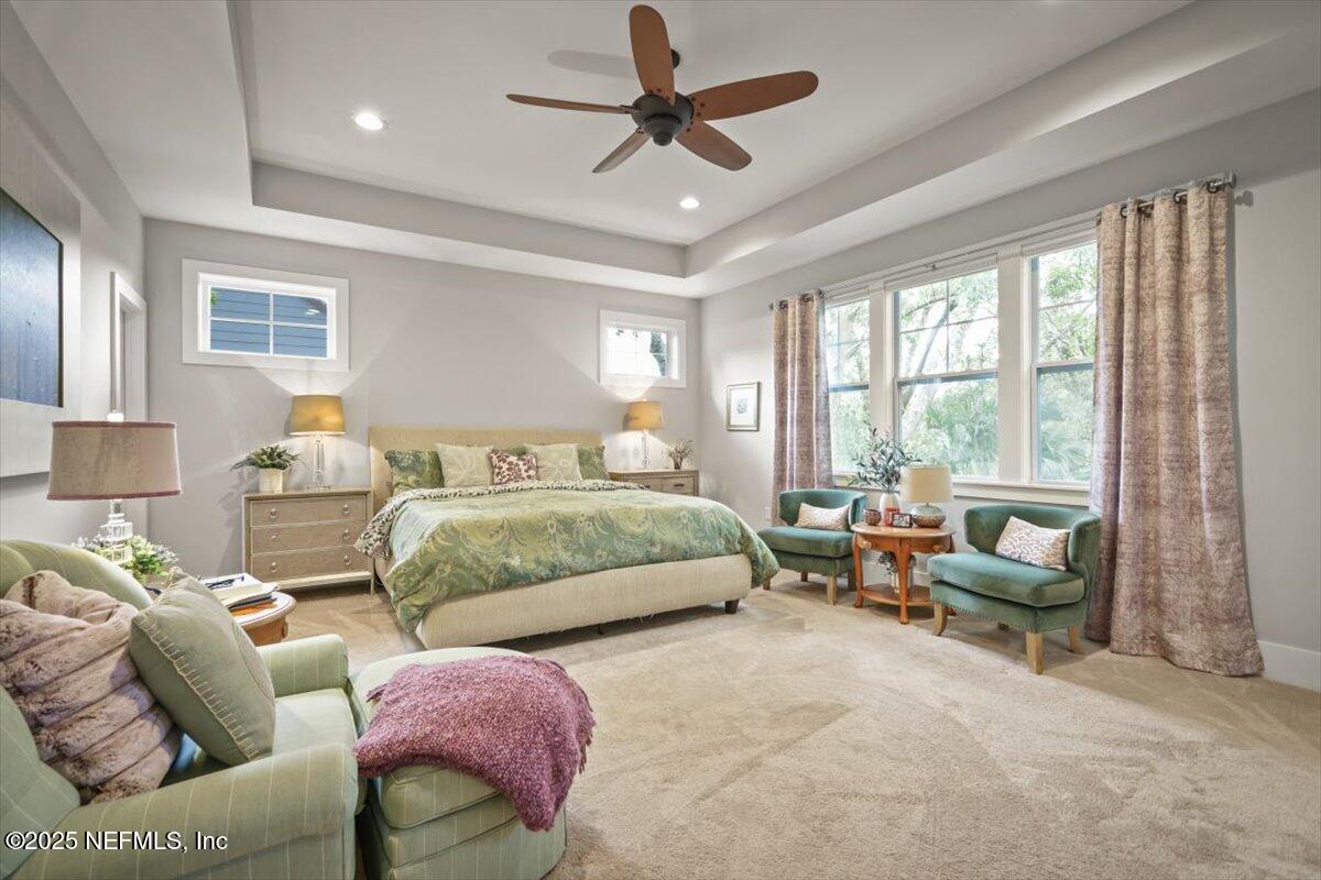 740 Paradise Lane Atlantic Beach, FL 32233 - Photo 28 of 38 a spacious bedroom with a bed a couch and a chandelier fan