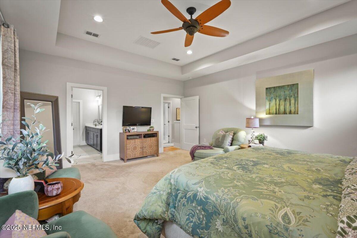 740 Paradise Lane Atlantic Beach, FL 32233 - Photo 29 of 38 a bedroom with a bed a flat screen tv and couches
