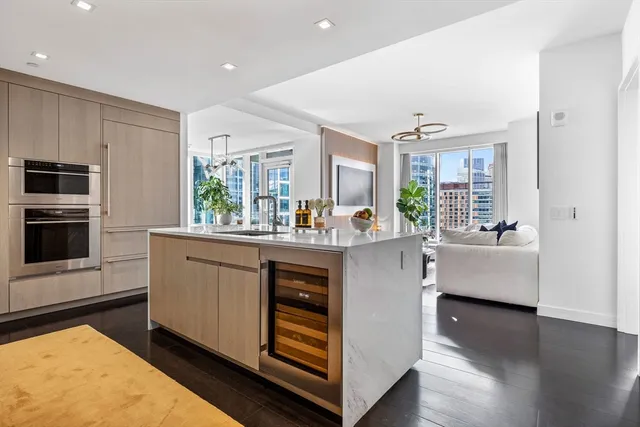 a kitchen with kitchen island white cabinets and stainless steel appliances