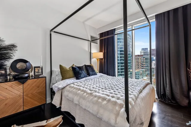 a bedroom with a bed and a large window