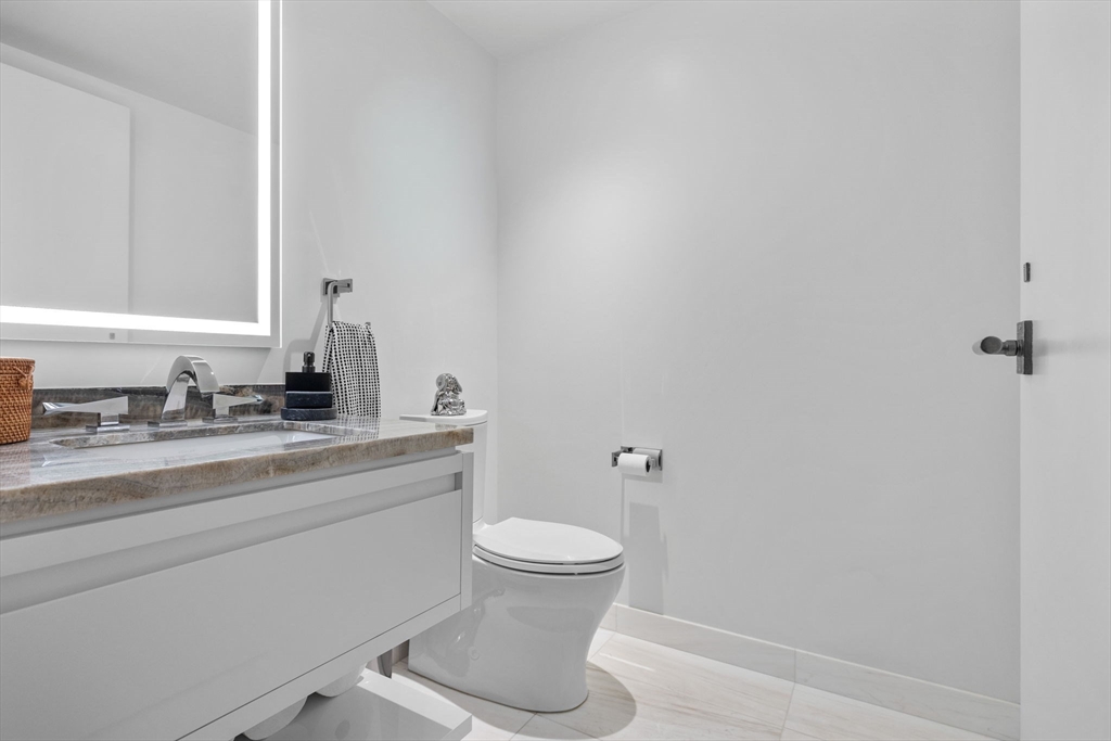 150 Seaport Boulevard, Unit 14B Boston, MA 02210 - Photo 29 of 42 a bathroom with a sink a toilet and a mirror