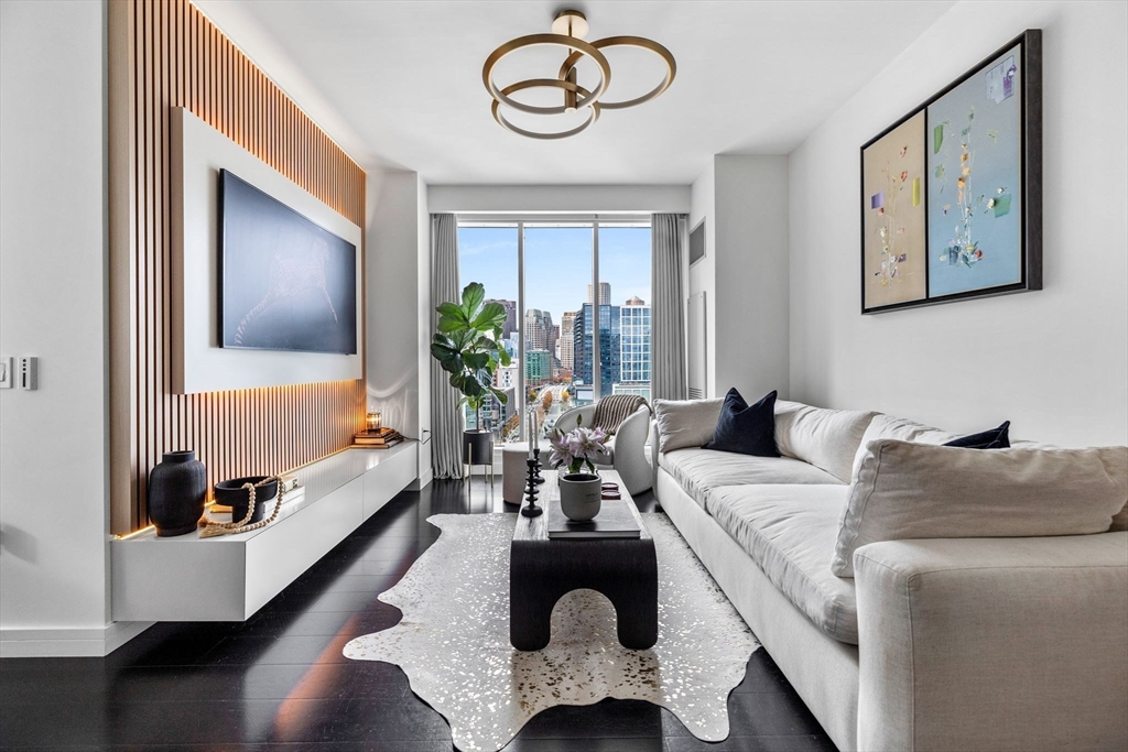 150 Seaport Boulevard, Unit 14B Boston, MA 02210 - Photo 3 of 42 a living room with furniture and a large window