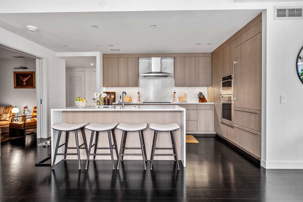 150 Seaport Boulevard, Unit 14B Boston, MA 02210 - Photo 8 of 42 a kitchen with a table chairs microwave and cabinets