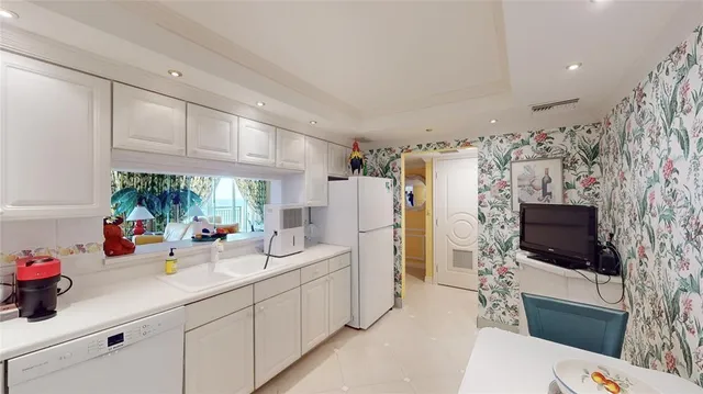 a kitchen with stainless steel appliances a sink cabinets and a window
