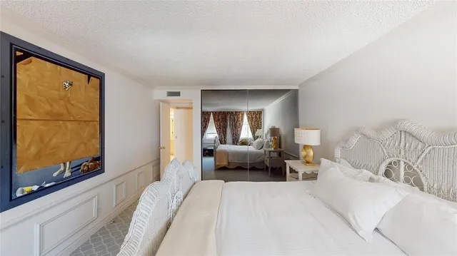 a spacious bedroom with a bed and a flat screen tv