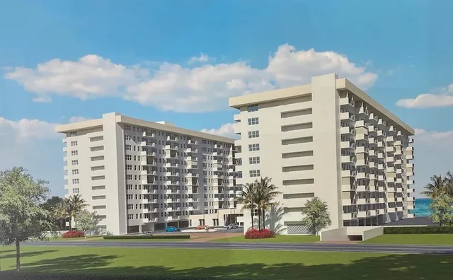 a front view of a building with glass windows and trees