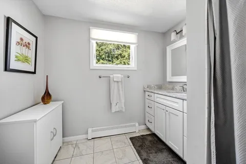 a bathroom with a sink a toilet and a window