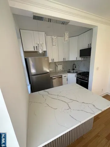 a kitchen with stainless steel appliances a refrigerator and microwave