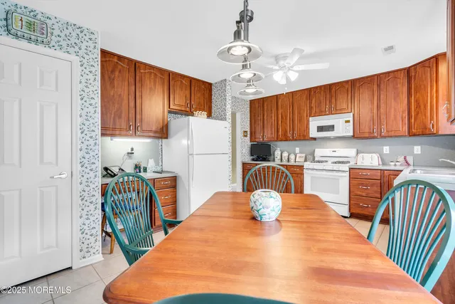 a kitchen with stainless steel appliances granite countertop a refrigerator a stove top oven a sink dishwasher and wooden cabinets with wooden floor