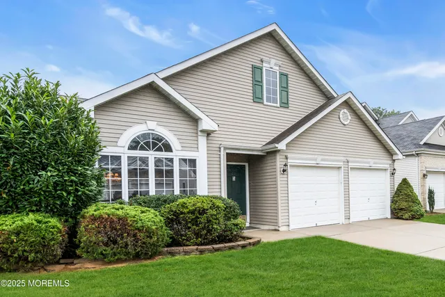 a view of a house with brick walls and a yard with plants