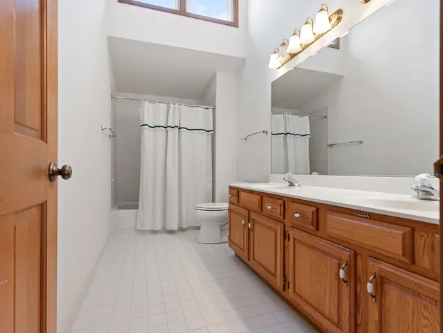 a spacious bedroom with a bed and dresser