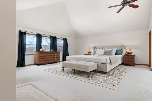 a large bedroom with a large bed and a chandelier