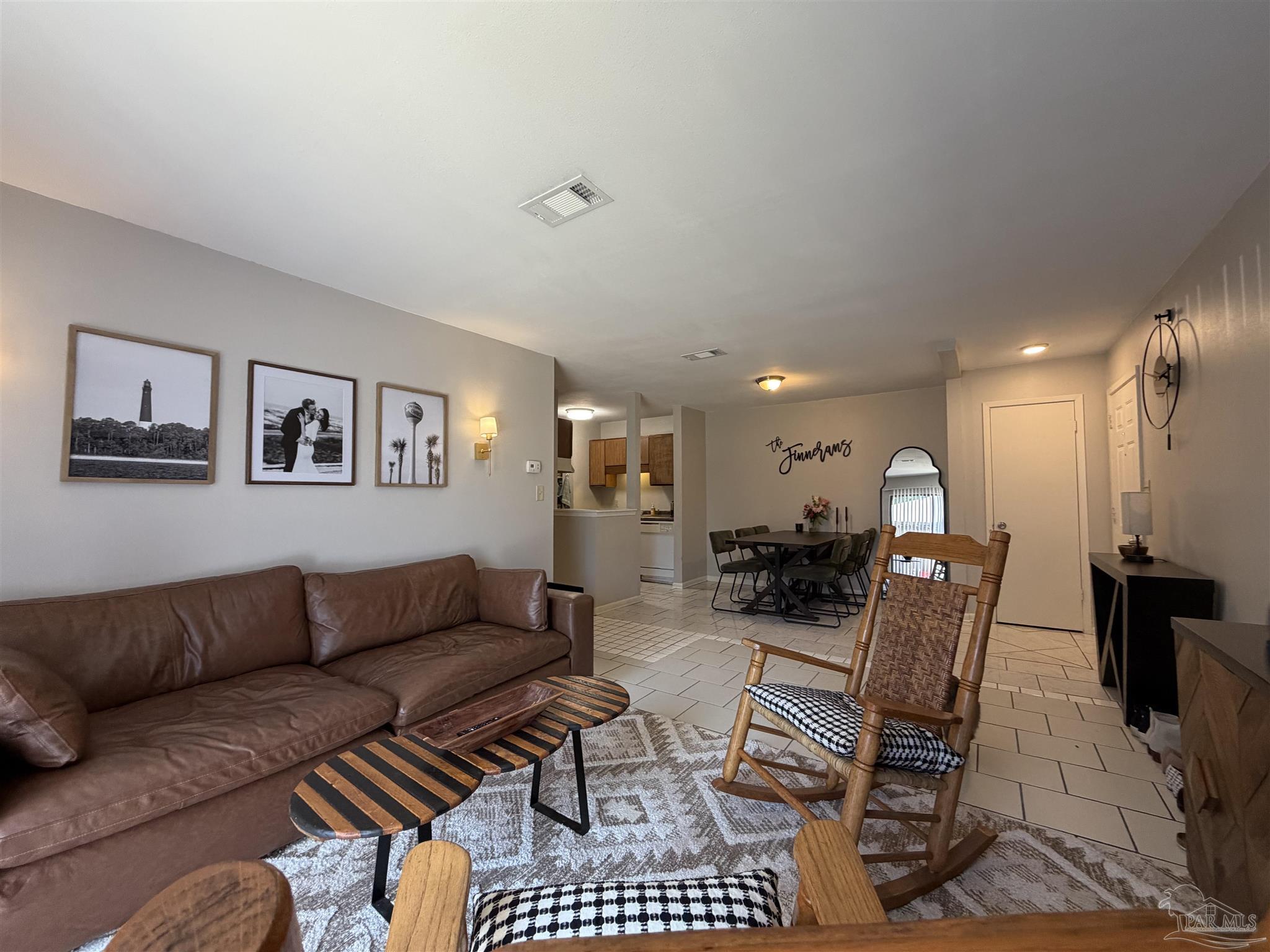 a living room with furniture and a dining table with kitchen view