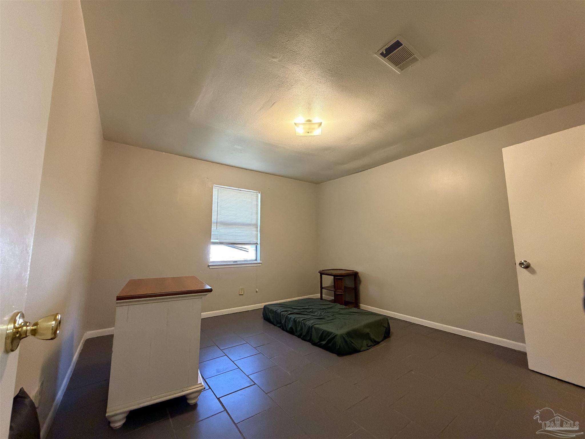 130 East 9 Mile Road, Unit 7 Pensacola, FL 32534 - Photo 24 of 61 a bedroom with a bed and a potted plant