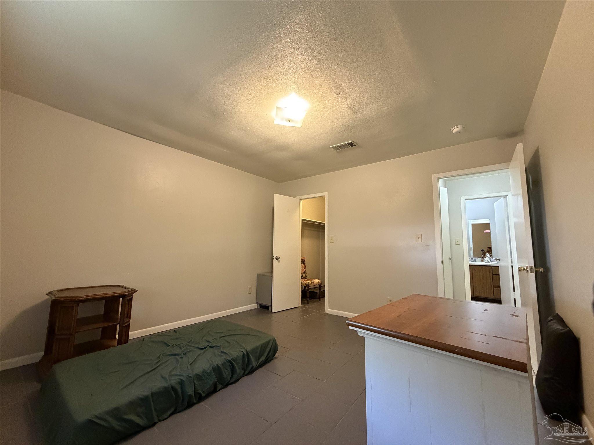 130 East 9 Mile Road, Unit 7 Pensacola, FL 32534 - Photo 25 of 61 a living room with a bed furniture and a flat screen tv