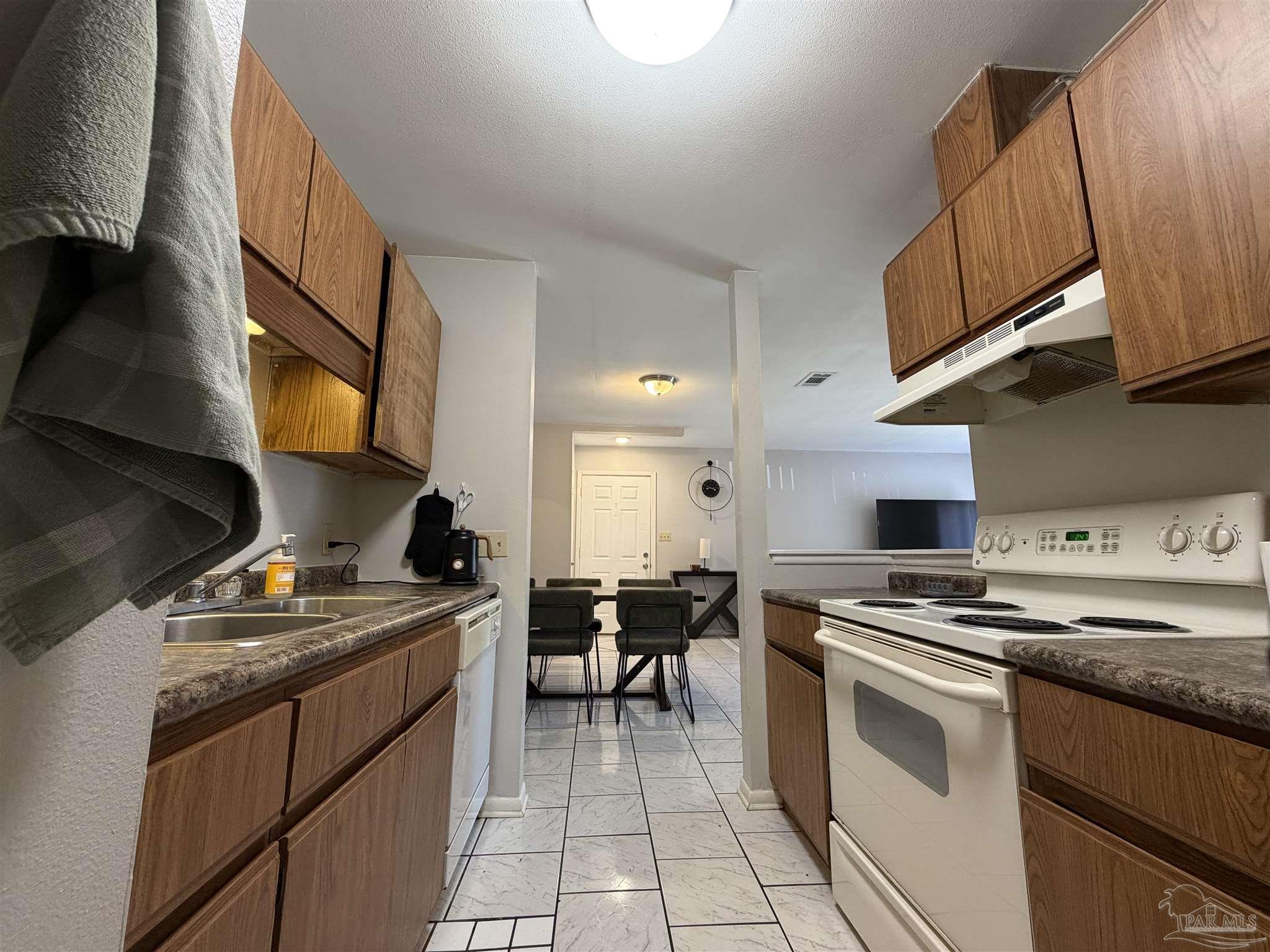 130 East 9 Mile Road, Unit 7 Pensacola, FL 32534 - Photo 34 of 61 a kitchen with stainless steel appliances a stove a sink dishwasher and a microwave oven with cabinets