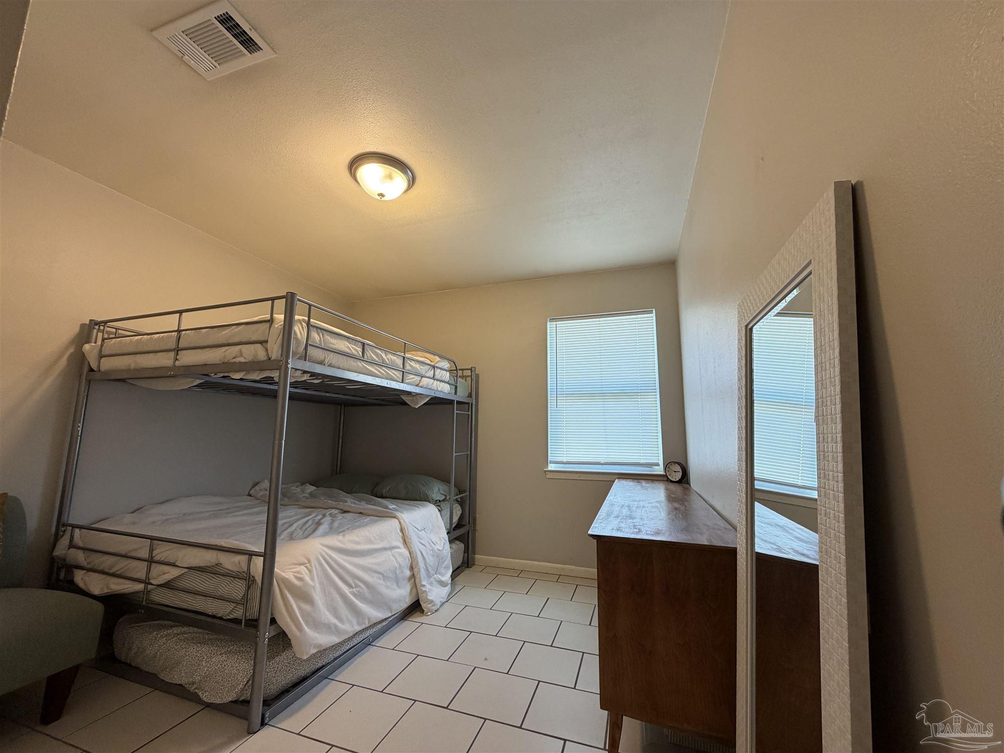 130 East 9 Mile Road, Unit 7 Pensacola, FL 32534 - Photo 36 of 61 a bedroom with a bed and a mirror