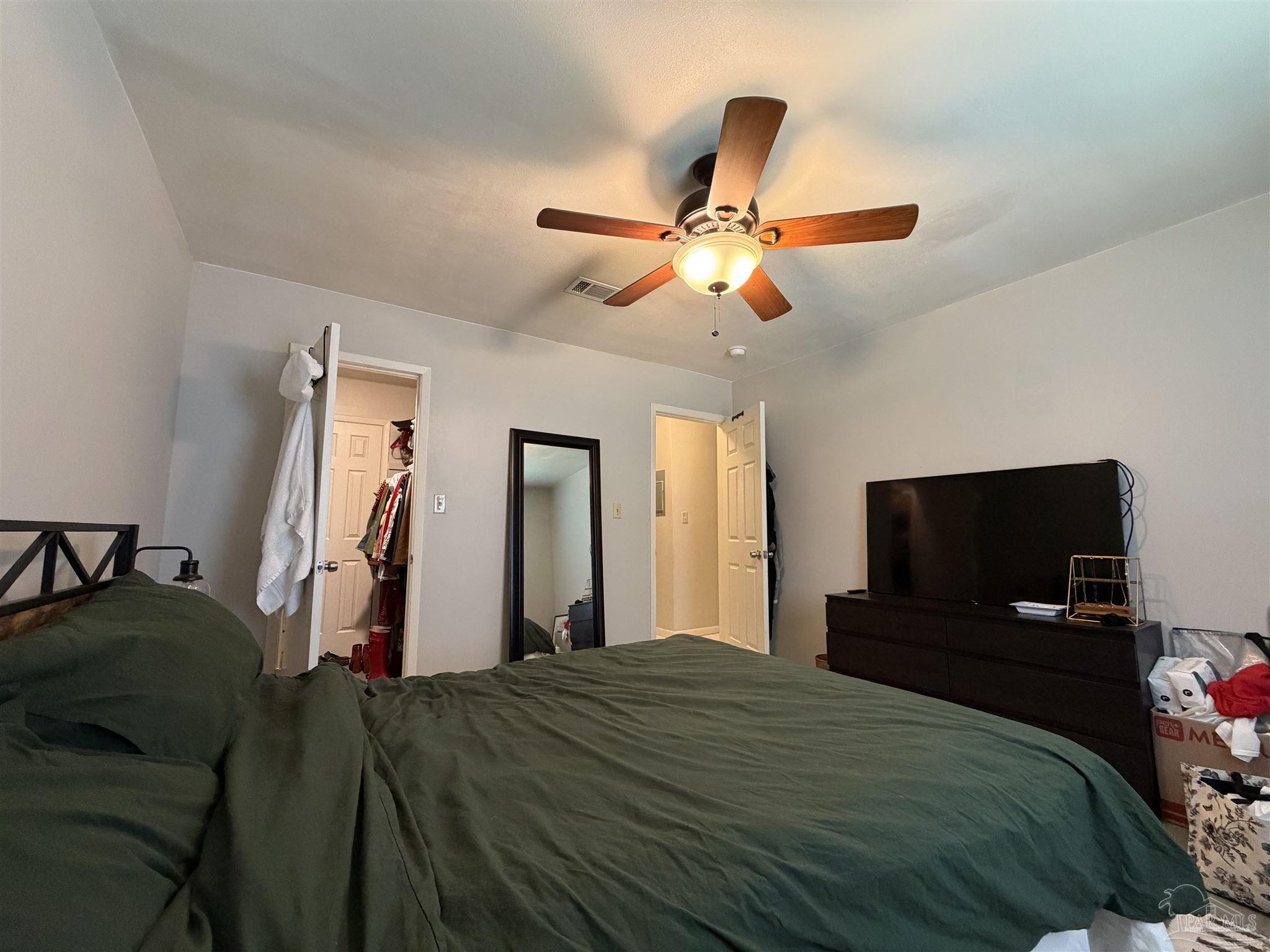 130 East 9 Mile Road, Unit 7 Pensacola, FL 32534 - Photo 47 of 61 a bedroom with a bed and a flat tv screen on the dresser