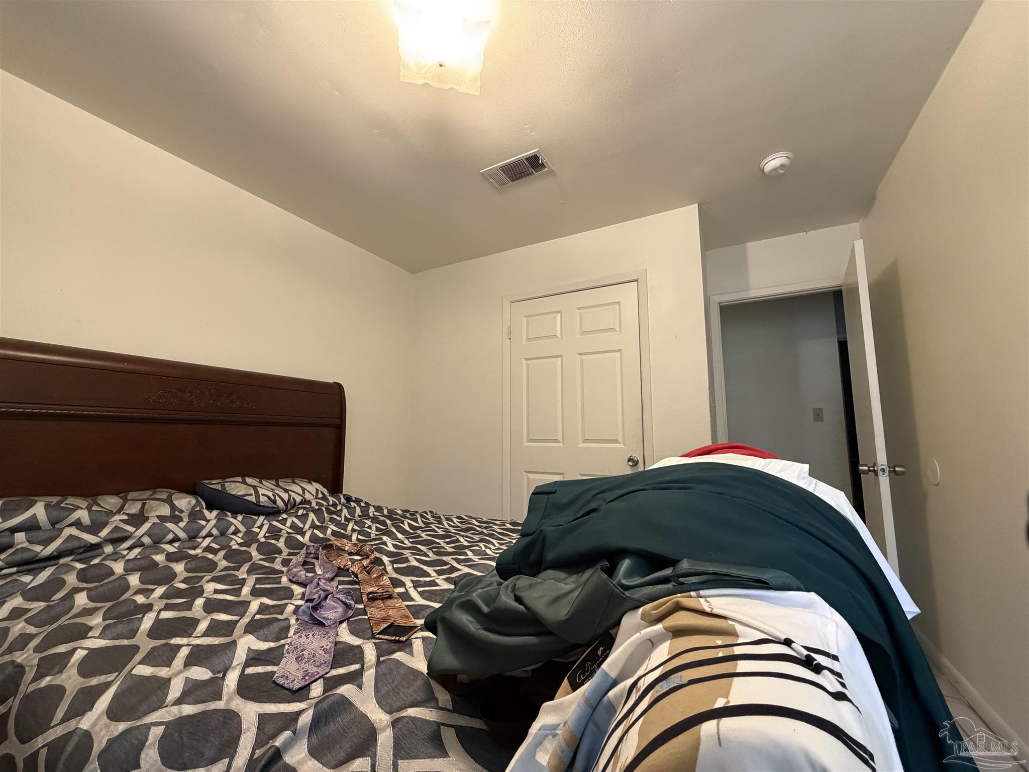 130 East 9 Mile Road, Unit 7 Pensacola, FL 32534 - Photo 55 of 61 a bedroom with a bed and a black white checkered floor