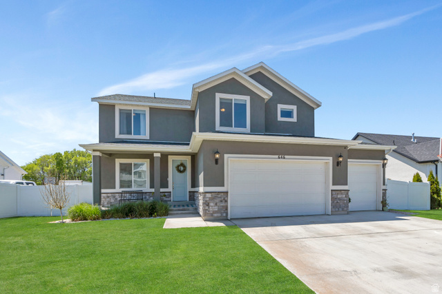 Contemporary two-story residence featuring a gray stucco exterior with stone accents
