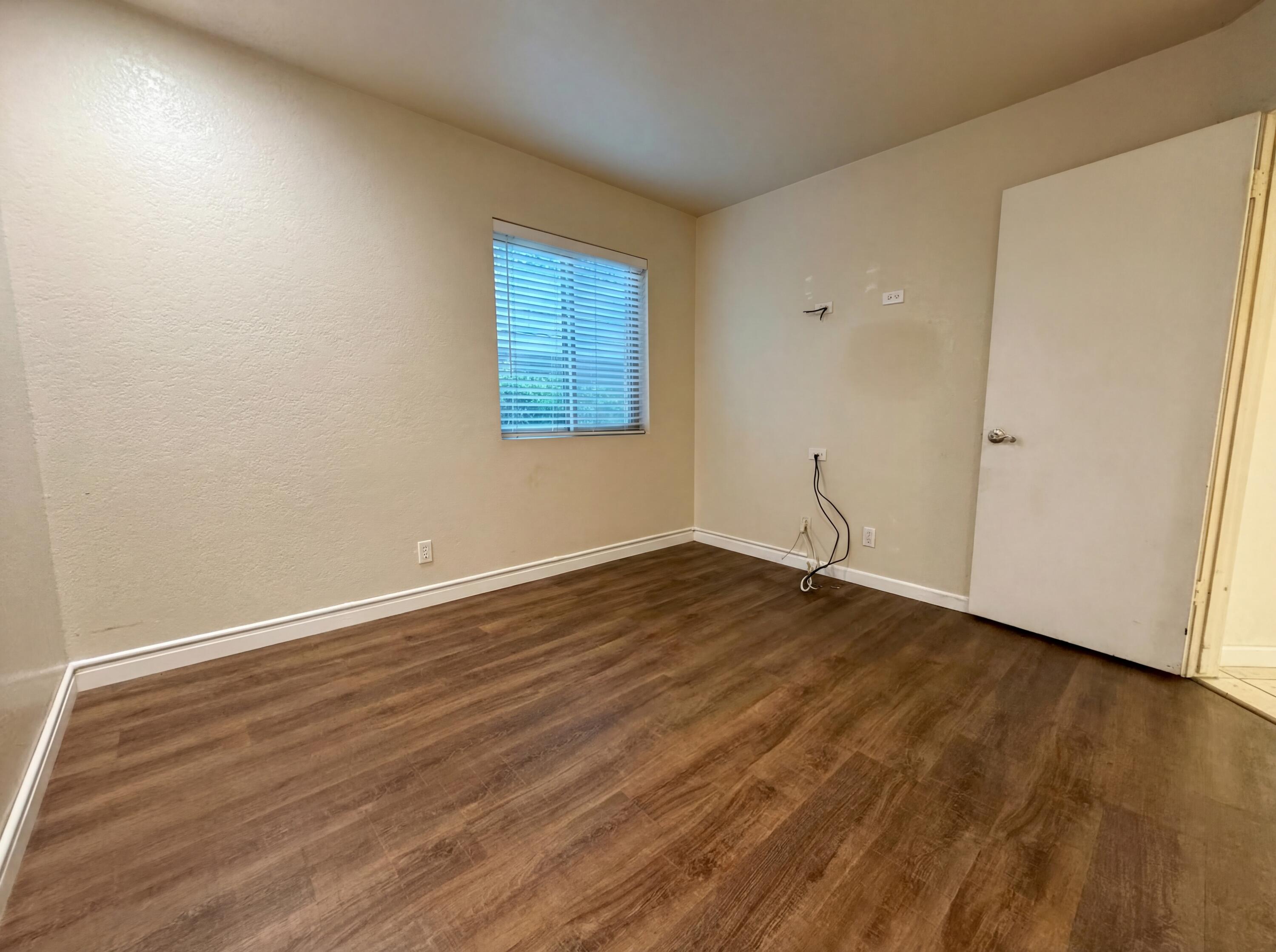 48255 Monroe Street, Unit 20 Indio, CA 92201 - Photo 14 of 21 a view of an empty room with wooden floor and a window