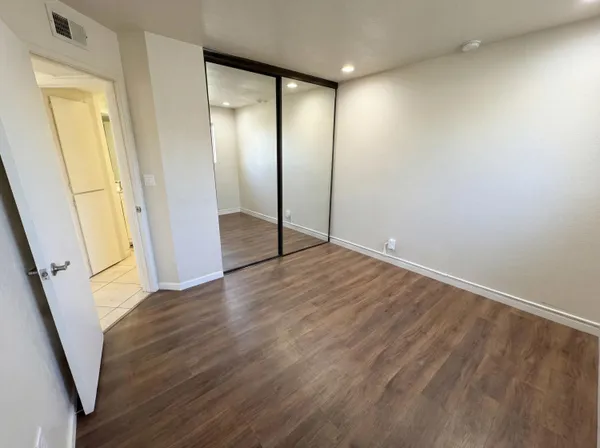 an empty room with wooden floor and door