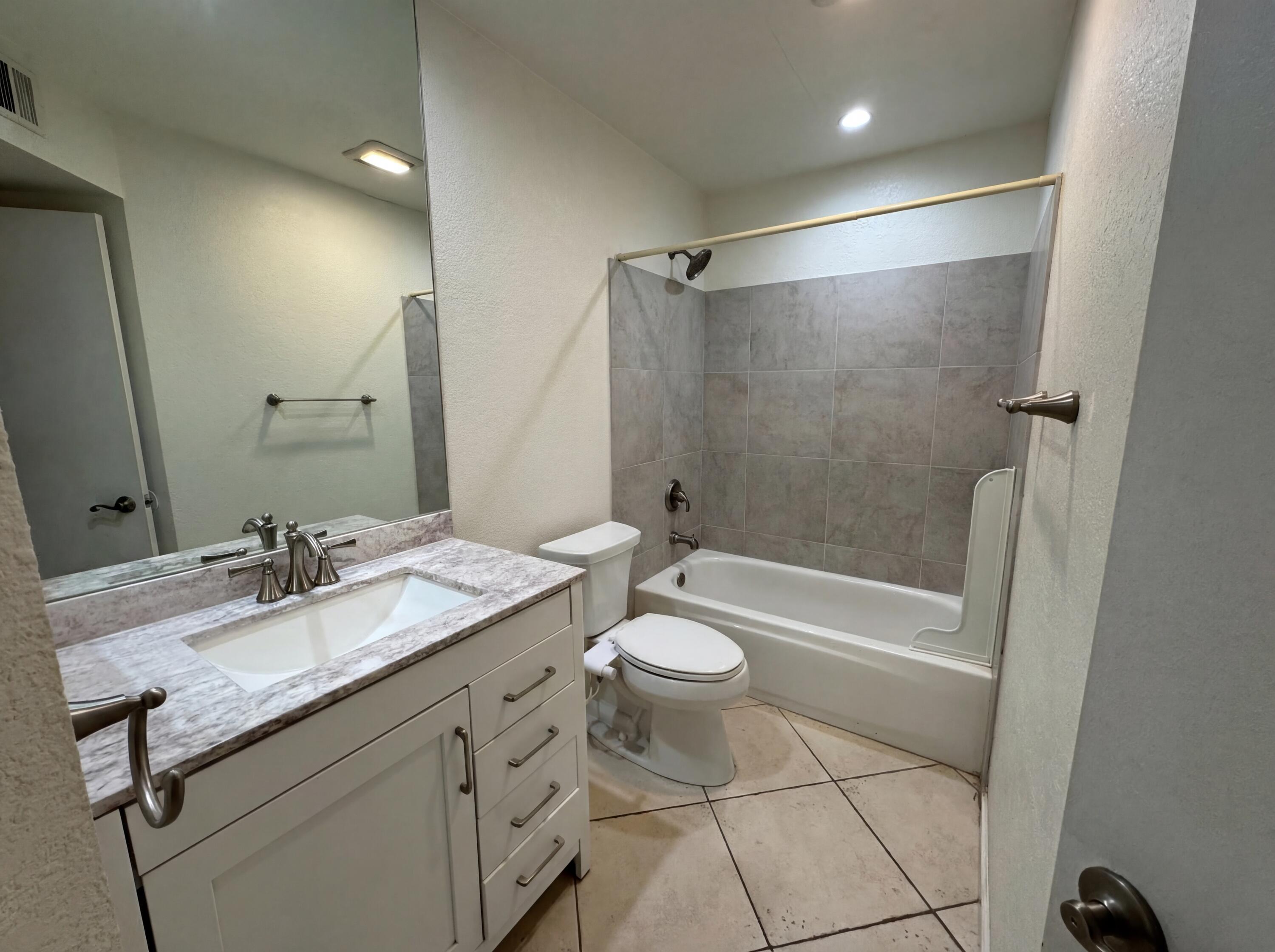 48255 Monroe Street, Unit 20 Indio, CA 92201 - Photo 16 of 21 a bathroom with a granite countertop sink a toilet and shower