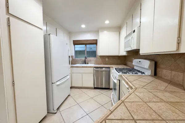 a kitchen with a sink a refrigerator and cabinets
