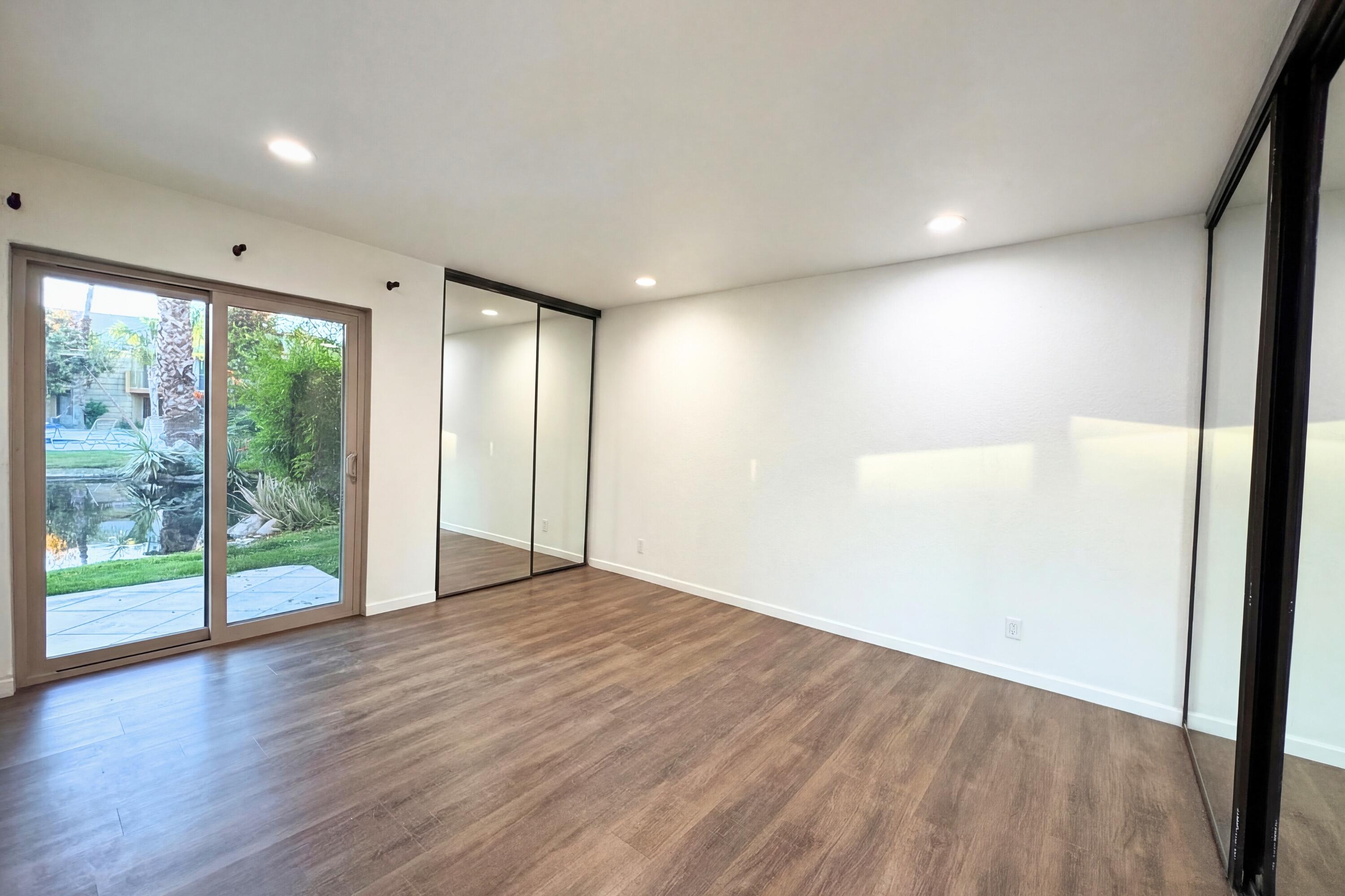 48255 Monroe Street, Unit 20 Indio, CA 92201 - Photo 9 of 21 a view of an empty room with wooden floor and a window