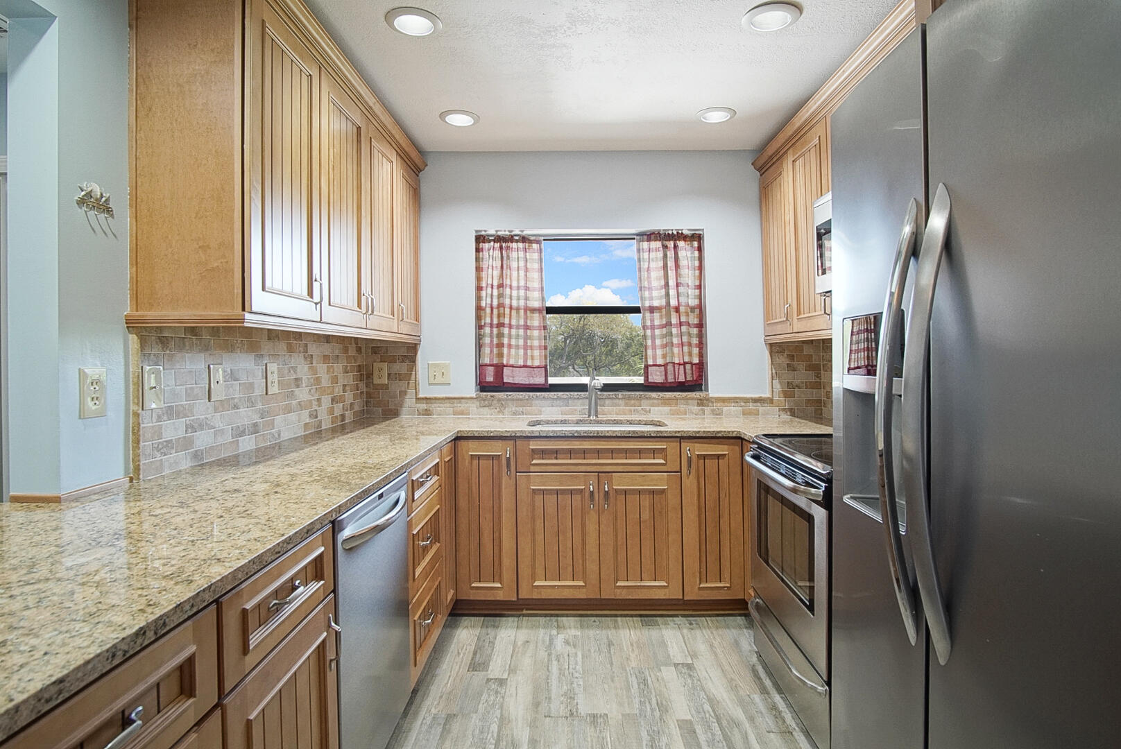 6041 Southeast Landing Way Stuart, FL 34997 - Photo 16 of 30 a kitchen with stainless steel appliances granite countertop a refrigerator and a sink