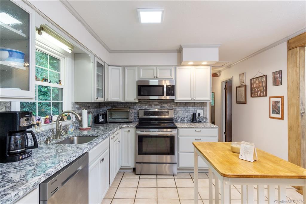 27 New Valley Road Swannanoa, NC 28778 - Photo 11 of 42 a kitchen with stainless steel appliances granite countertop a stove top oven a sink dishwasher and a refrigerator