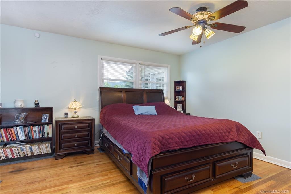 27 New Valley Road Swannanoa, NC 28778 - Photo 16 of 42 a bedroom with a bed a dresser and book shelf