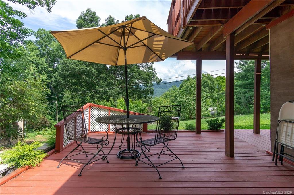 27 New Valley Road Swannanoa, NC 28778 - Photo 38 of 42 a view of a patio with table and chairs under an umbrella with a small yard