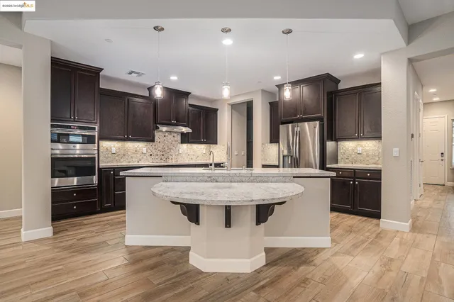 a kitchen with kitchen island stainless steel appliances a sink and refrigerator