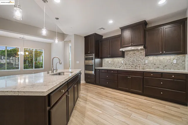 a kitchen with a granite countertop sink and stainless steel appliances