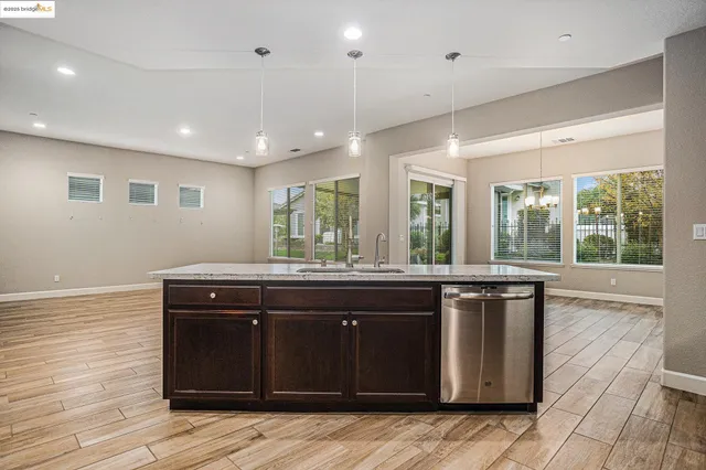 a kitchen with kitchen island granite countertop a stove and a sink