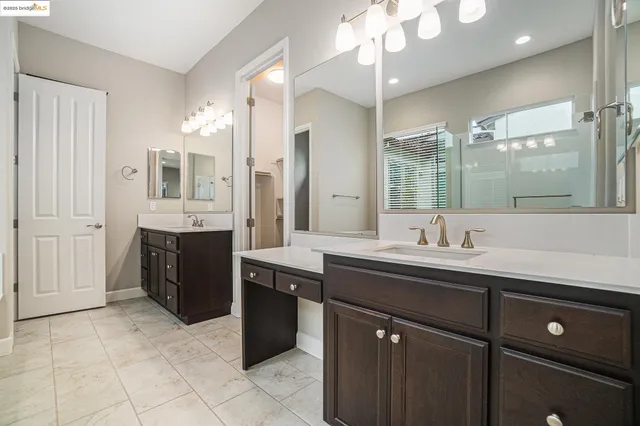 a spacious bathroom with a granite countertop sink a toilet a mirror and shower