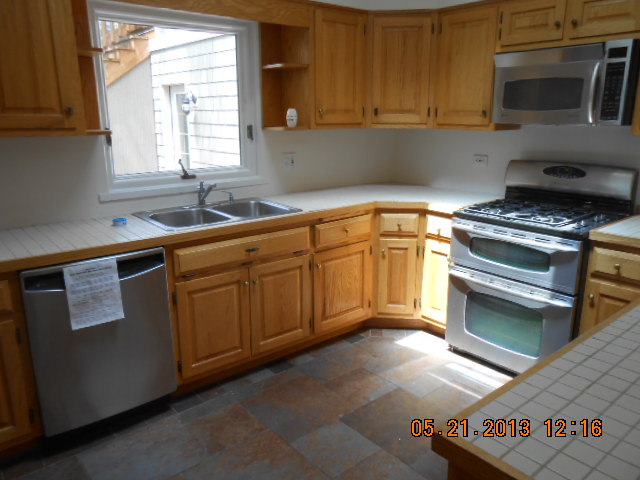 1512 Daly Road Wheaton, IL 60187 - Photo 10 of 20 a kitchen with stainless steel appliances granite countertop a sink stove and microwave