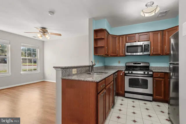 a kitchen with granite countertop a stove top oven microwave and cabinets