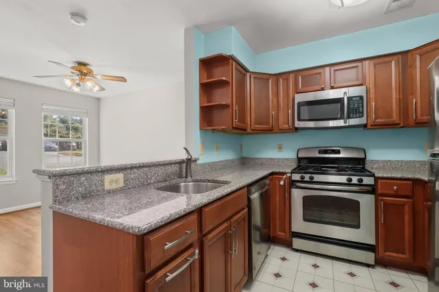 a kitchen with granite countertop a refrigerator stove and microwave