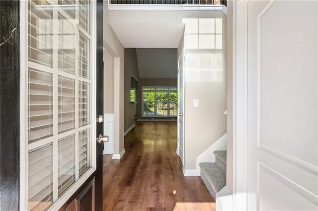 a view of a hallway with wooden floor and staircase