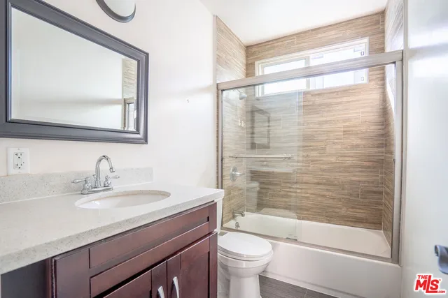 a bathroom with a bathtub shower sink vanity and toilet
